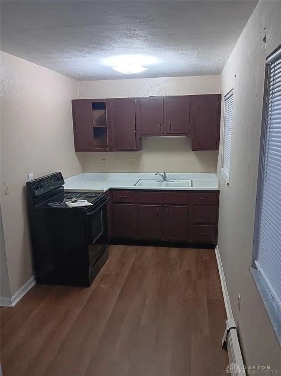 4129 E 3rd St Unit 4127, Dayton, OH 45403 - kitchen featuring black range with electric stovetop, dark wood-style floors, light countertops, a textured ceiling, and a baseboard radiator
