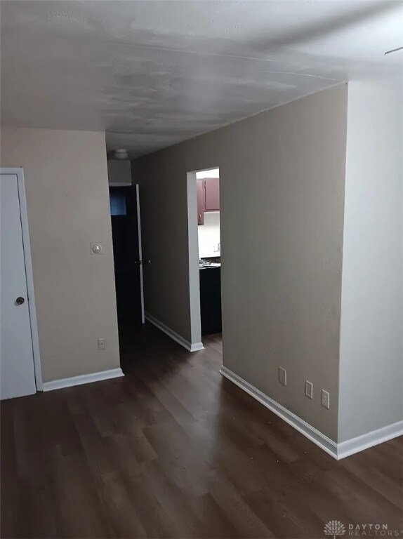 4129 E 3rd St Unit 4127, Dayton, OH 45403 - spare room with dark wood-type flooring and baseboards