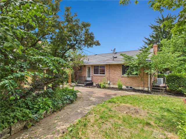 2120 Wyoming St, Dayton, OH 45410 - back of house with brick siding, a chimney, and roof with shingles