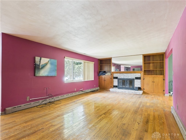 2120 Wyoming St, Dayton, OH 45410 - unfurnished living room featuring a baseboard radiator, hardwood / wood-style flooring, a brick fireplace, and built in shelves