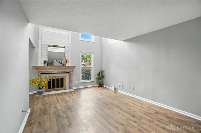 8052 Timberlodge Trl, Washington Twp, OH 45458 - unfurnished living room featuring wood finished floors, a textured ceiling, and a fireplace with flush hearth