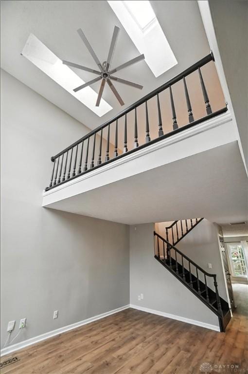 8052 Timberlodge Trl, Washington Twp, OH 45458 - staircase featuring a skylight, wood finished floors, a ceiling fan, and a high ceiling