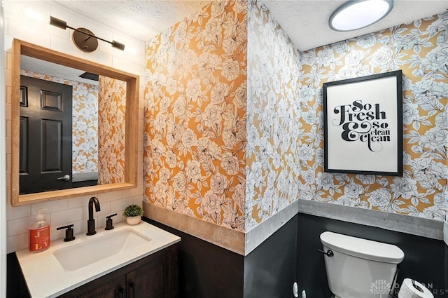 8052 Timberlodge Trl, Washington Twp, OH 45458 - half bath featuring a textured ceiling, wallpapered walls, backsplash, and vanity