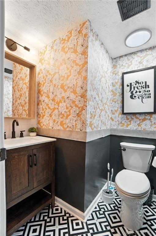 8052 Timberlodge Trl, Washington Twp, OH 45458 - bathroom featuring wallpapered walls, a wainscoted wall, vanity, and a textured ceiling