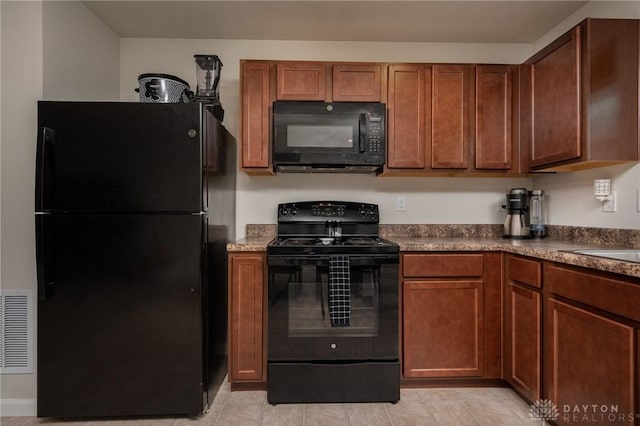 1009 Glen Kegley Dr, Xenia, OH 45385 - kitchen with black appliances, light tile patterned floors, brown cabinetry, and dark countertops