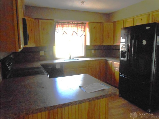 1930 Emerald Ct, Dayton, OH 45403 - kitchen with black refrigerator with ice dispenser, a peninsula, light brown cabinets, and stove