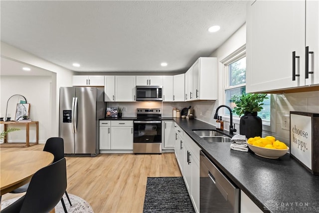 1209 Maple St, Troy, OH 45373 - kitchen with stainless steel appliances, dark countertops, white cabinetry, light wood-style flooring, and recessed lighting