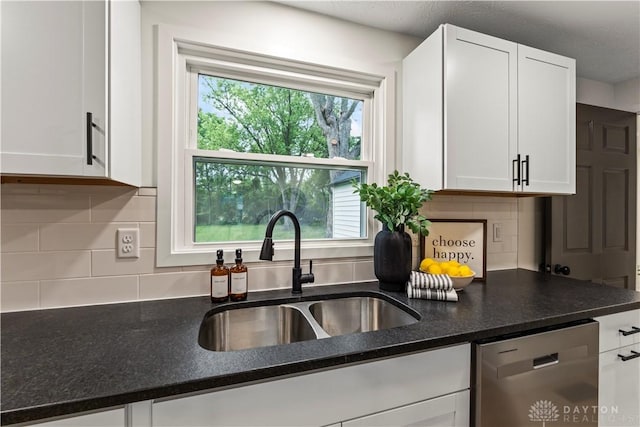 1209 Maple St, Troy, OH 45373 - kitchen with stainless steel dishwasher, white cabinetry, backsplash, and dark stone countertops