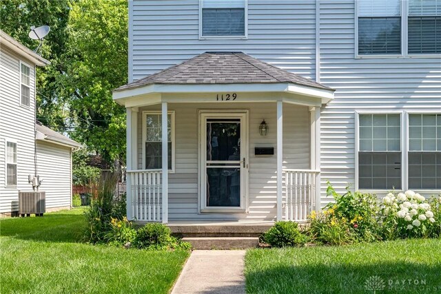 1129 Eureka Dr, Kettering, OH 45419 - property entrance featuring roof with shingles, a porch, and a lawn