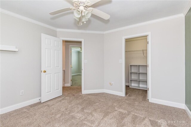1129 Eureka Dr, Kettering, OH 45419 - unfurnished bedroom featuring crown molding, carpet, a walk in closet, ceiling fan, and a closet