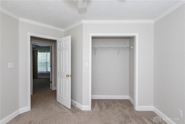 1129 Eureka Dr, Kettering, OH 45419 - unfurnished bedroom featuring carpet flooring, ornamental molding, a closet, and a ceiling fan