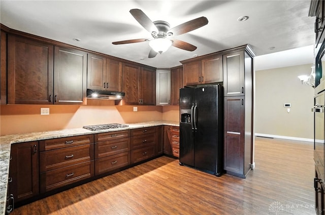118 Hill St, Xenia, OH 45385 - kitchen featuring black fridge, under cabinet range hood, stainless steel gas cooktop, wood finished floors, and recessed lighting