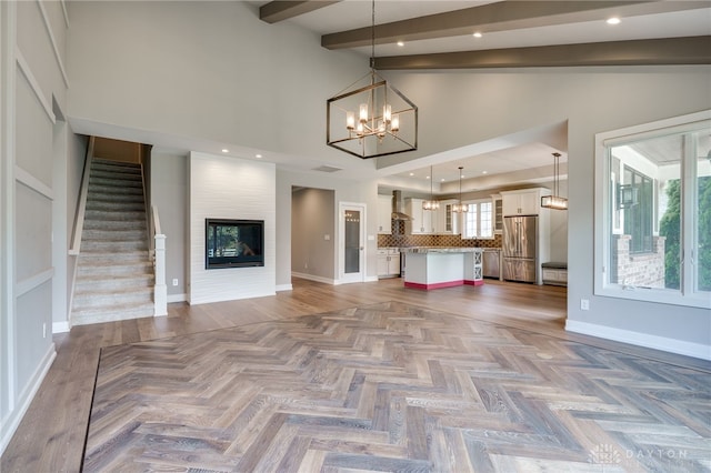 1461 Abbey Park Pl, Beavercreek Twp, OH 45385 - unfurnished living room featuring a chandelier, beam ceiling, stairway, and high vaulted ceiling