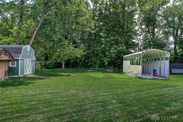 5136 Oleva Dr, Sugarcreek Twp, OH 45440 - view of green lawn featuring a storage shed, a detached carport, and view of wooded area