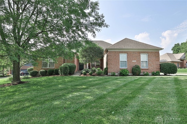 595 Heatherwoode Cir, Springboro, OH 45066 - view of front of home with a front yard, brick siding, and roof with shingles