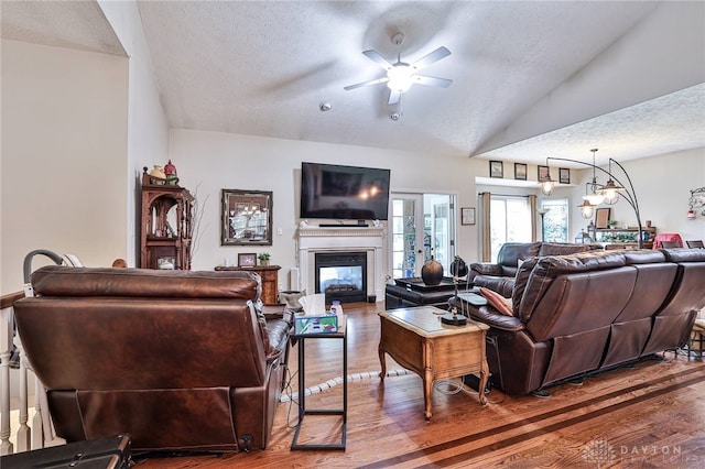 595 Heatherwoode Cir, Springboro, OH 45066 - living room featuring a ceiling fan, a textured ceiling, wood finished floors, a glass covered fireplace, and vaulted ceiling