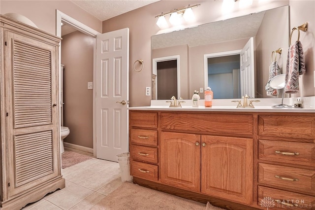 595 Heatherwoode Cir, Springboro, OH 45066 - bathroom featuring double vanity, tile patterned flooring, a textured ceiling, and a closet