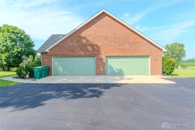 1061 Mcpherson Rd, Xenia, OH 45385 - view of side of home featuring brick siding, a garage, and driveway