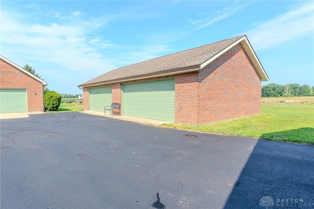 1061 Mcpherson Rd, Xenia, OH 45385 - view of home's exterior featuring a detached garage, a lawn, and brick siding