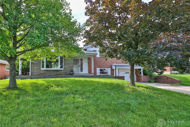 1095 Susan Dr, Hamilton, OH 45013 - view of front of house with an attached garage, a front lawn, brick siding, driveway, and stone siding
