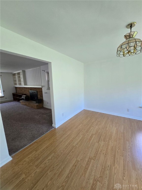 1095 Susan Dr, Hamilton, OH 45013 - unfurnished living room with light wood-style flooring and a fireplace