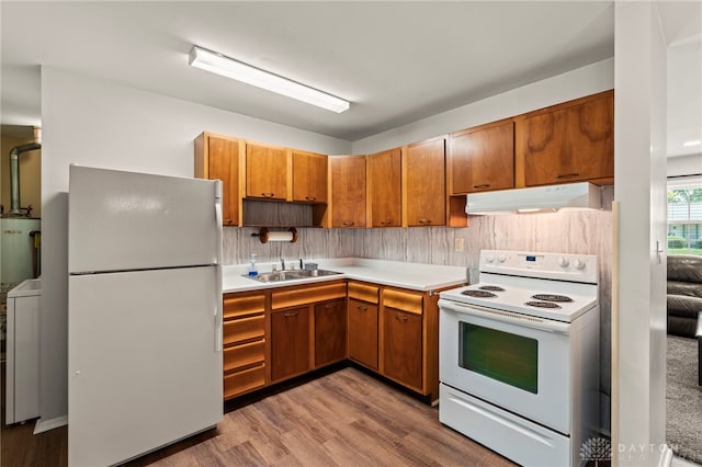 1021 Nutmeg Sq, Troy, OH 45373 - kitchen featuring white appliances, under cabinet range hood, wood finished floors, brown cabinets, and light countertops