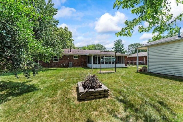 1021 Nutmeg Sq, Troy, OH 45373 - view of grassy yard featuring a sunroom and an outdoor fire pit