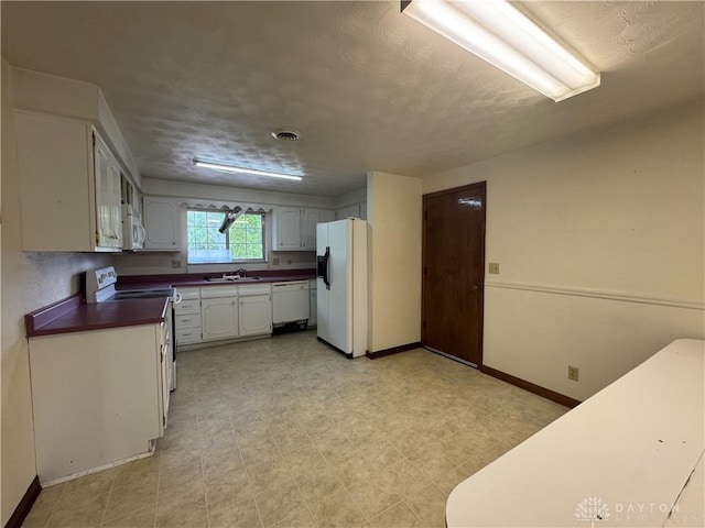 2886 Kemp Rd, Beavercreek, OH 45431 - kitchen featuring white appliances, dark countertops, and white cabinets