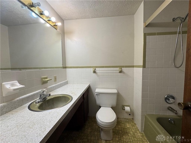 2886 Kemp Rd, Beavercreek, OH 45431 - full bathroom with vanity, bathtub / shower combination, tile walls, wainscoting, and a textured ceiling