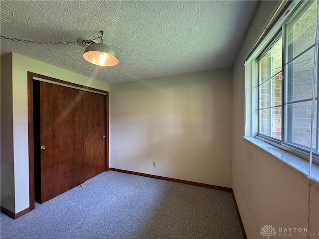 2886 Kemp Rd, Beavercreek, OH 45431 - unfurnished bedroom featuring a closet, a textured ceiling, and carpet flooring