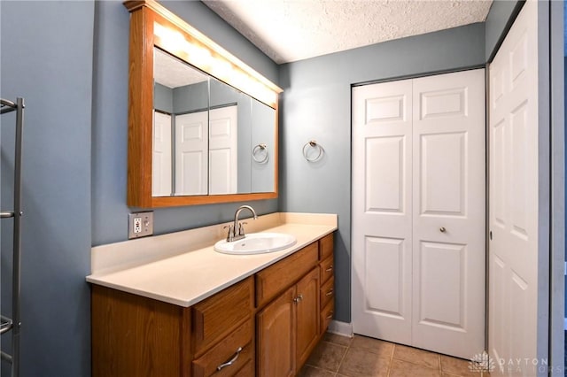 174 Tuxworth Rd, Dayton, OH 45458 - bathroom featuring a closet, vanity, tile patterned flooring, and a textured ceiling