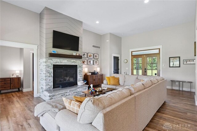 9782 E US Highway 22 And 3, Clarksville, OH 45113 - living room with wood finished floors, a stone fireplace, recessed lighting, a high ceiling, and french doors