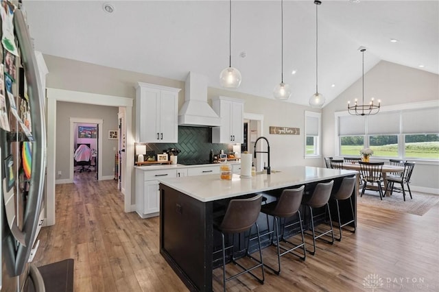 9782 E US Highway 22 And 3, Clarksville, OH 45113 - kitchen with custom exhaust hood, light countertops, white cabinetry, a center island with sink, and high vaulted ceiling