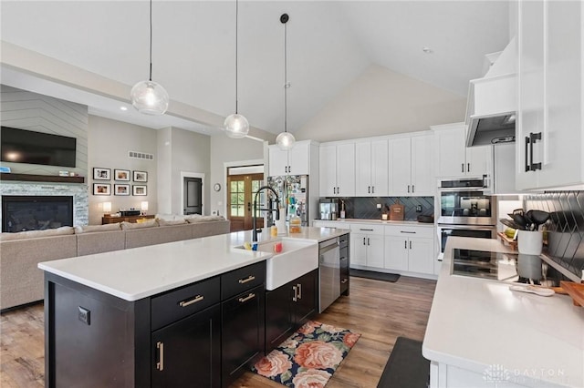 9782 E US Highway 22 And 3, Clarksville, OH 45113 - kitchen with high vaulted ceiling, stainless steel appliances, light countertops, white cabinets, and dark cabinetry
