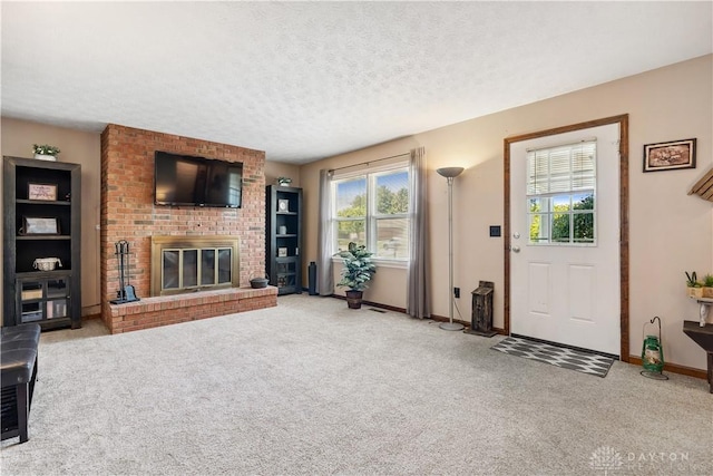222 Alumni Cir, Wilmington, OH 45177 - unfurnished living room with plenty of natural light, light carpet, a brick fireplace, and a textured ceiling