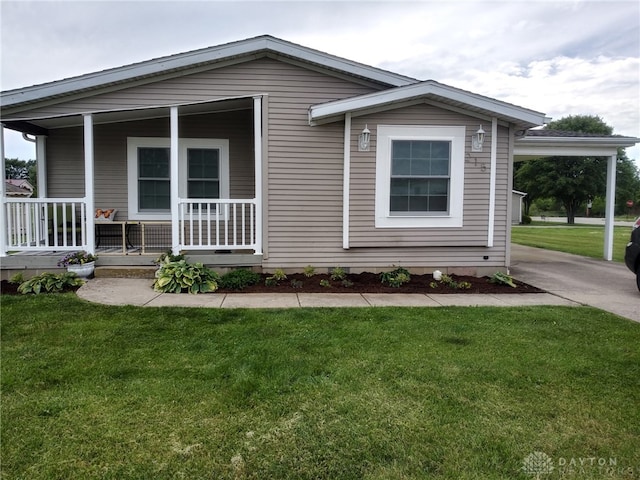 215 Taylor Dr, Wilmington, OH 45177 - view of front facade with covered porch, a front yard, and concrete driveway