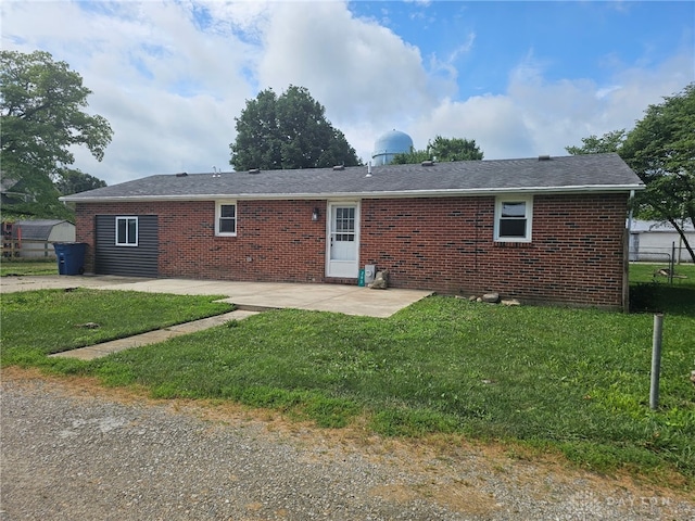 283 Moore St, Lewisburg, OH 45338 - back of house with brick siding, a patio, a lawn, and a shingled roof