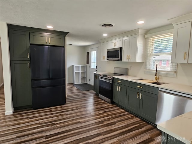 283 Moore St, Lewisburg, OH 45338 - kitchen with appliances with stainless steel finishes, dark wood finished floors, white cabinetry, plenty of natural light, and recessed lighting