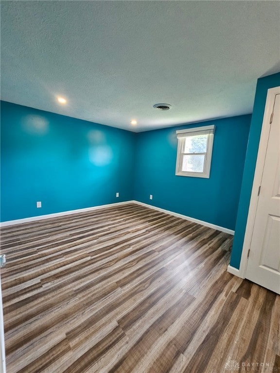 283 Moore St, Lewisburg, OH 45338 - spare room featuring wood finished floors, a textured ceiling, and recessed lighting