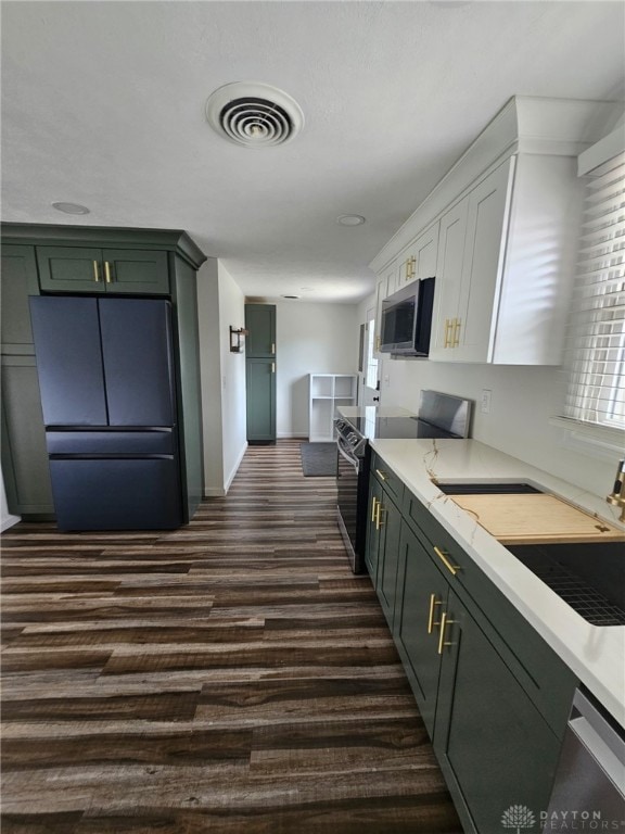 283 Moore St, Lewisburg, OH 45338 - kitchen featuring stainless steel microwave, range with electric cooktop, freestanding refrigerator, dark wood-type flooring, and white cabinetry
