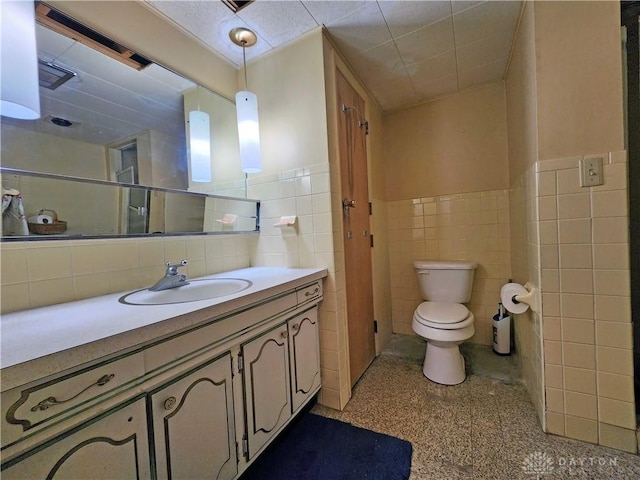 851 E County Line Rd, Springfield, OH 45502 - bathroom featuring tile walls, vanity, a wainscoted wall, and speckled floor