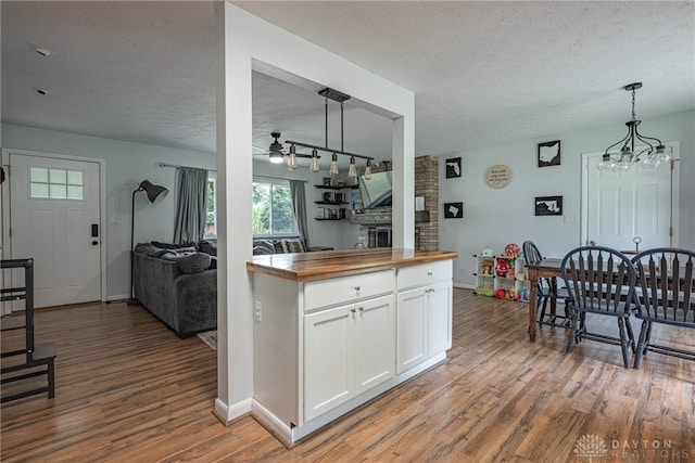 3442 Longleaf Ave, Beavercreek, OH 45430 - kitchen with butcher block counters, light wood-style flooring, a textured ceiling, white cabinets, and a ceiling fan