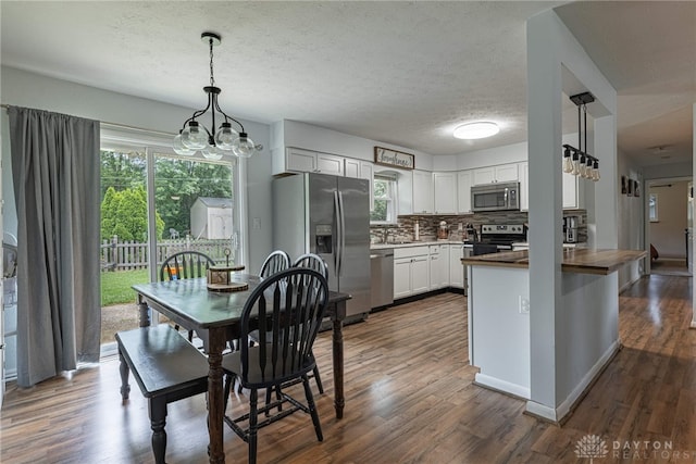 3442 Longleaf Ave, Beavercreek, OH 45430 - kitchen with stainless steel appliances, decorative backsplash, a peninsula, dark wood-type flooring, and a textured ceiling