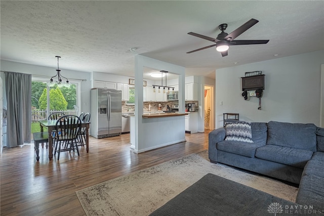 3442 Longleaf Ave, Beavercreek, OH 45430 - living area with wood finished floors, a ceiling fan, a textured ceiling, and a chandelier