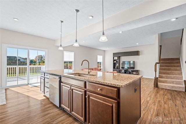 1835 Winding Run, Clearcreek Twp, OH 45458 - kitchen with stainless steel dishwasher, wood finished floors, a kitchen island with sink, light stone countertops, and decorative light fixtures