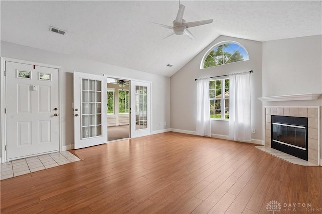 2782 Stefan Pl, Beavercreek, OH 45431 - unfurnished living room featuring ceiling fan, a tile fireplace, vaulted ceiling, and wood finished floors