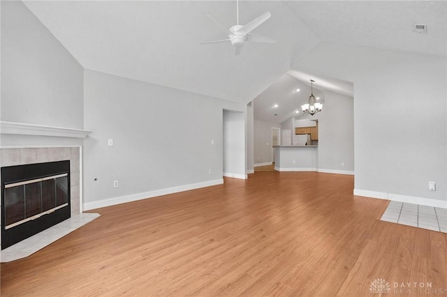 2782 Stefan Pl, Beavercreek, OH 45431 - unfurnished living room with lofted ceiling, ceiling fan, a chandelier, a fireplace, and light wood-style flooring