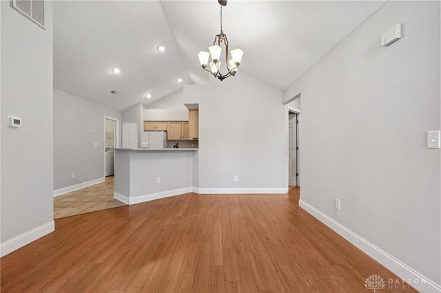 2782 Stefan Pl, Beavercreek, OH 45431 - unfurnished living room with a chandelier, vaulted ceiling, light wood finished floors, and recessed lighting
