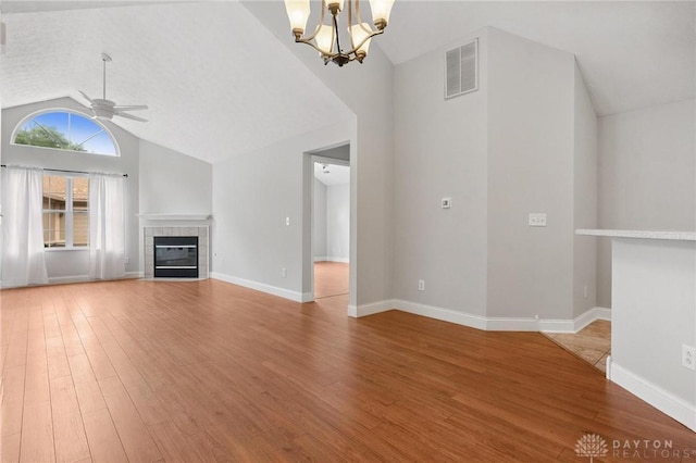 2782 Stefan Pl, Beavercreek, OH 45431 - unfurnished living room with vaulted ceiling, a ceiling fan, light wood finished floors, a tile fireplace, and a chandelier