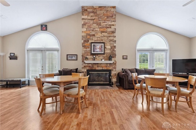 2782 Stefan Pl, Beavercreek, OH 45431 - dining area with light wood-type flooring, high vaulted ceiling, a stone fireplace, and ceiling fan